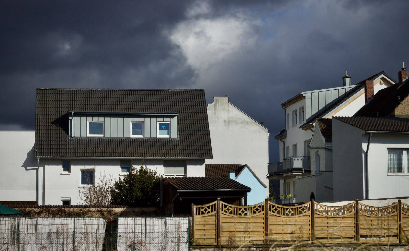 Home standing under a heavy storm sky with a sound roof