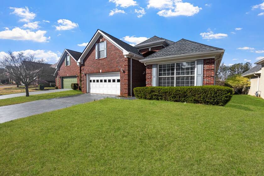 Brick home with a fresh composition roof under a clear sky