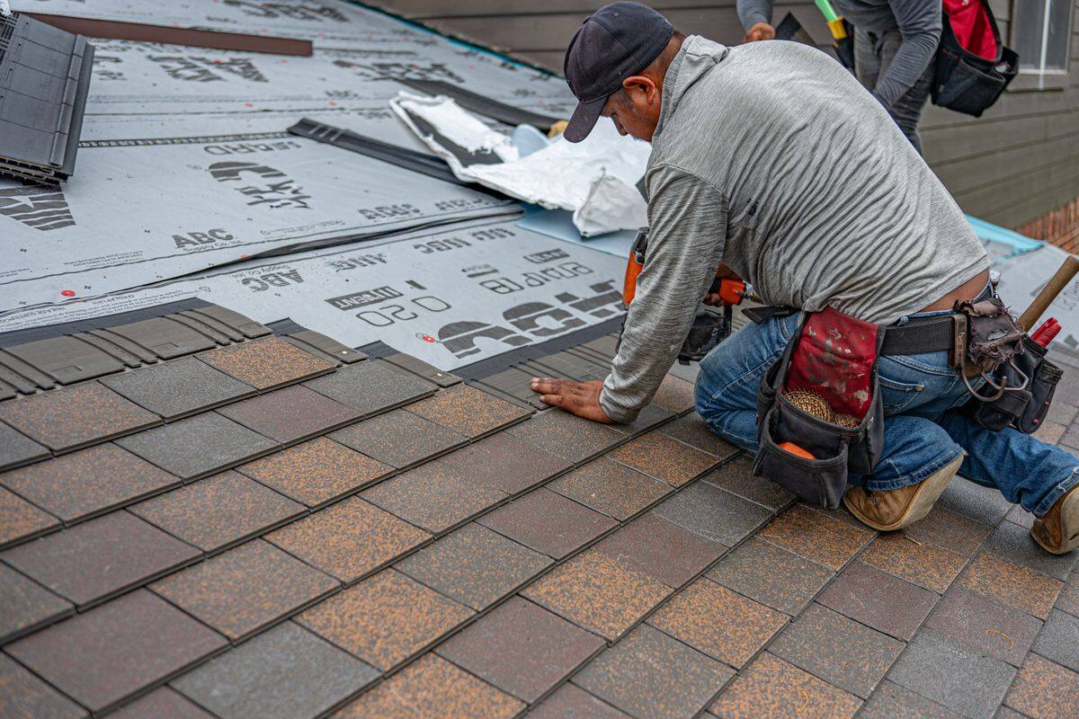 Tulsa Quality Roofing installer laying architectural shingles over fresh underlayment